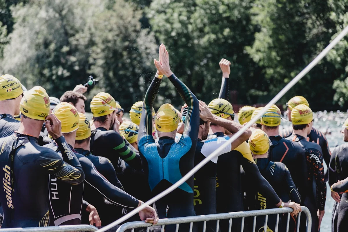 Groupe de triathlètes en combinaison au départ de la natation